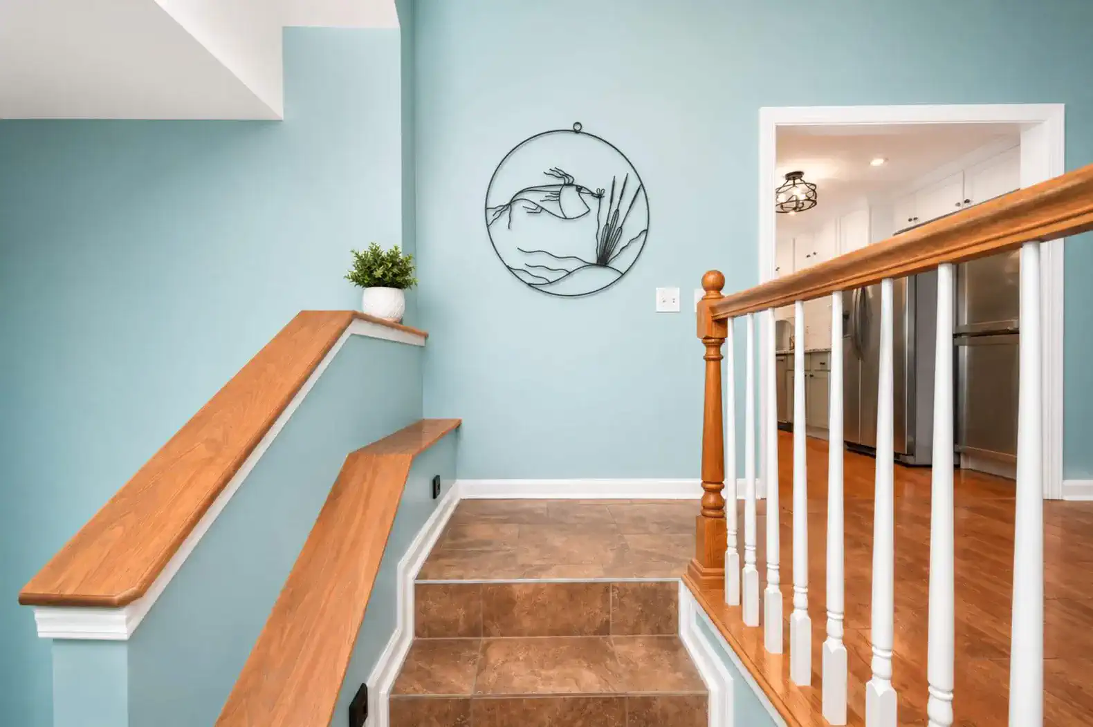 Staircase leading to a light blue wall with decorative wall art