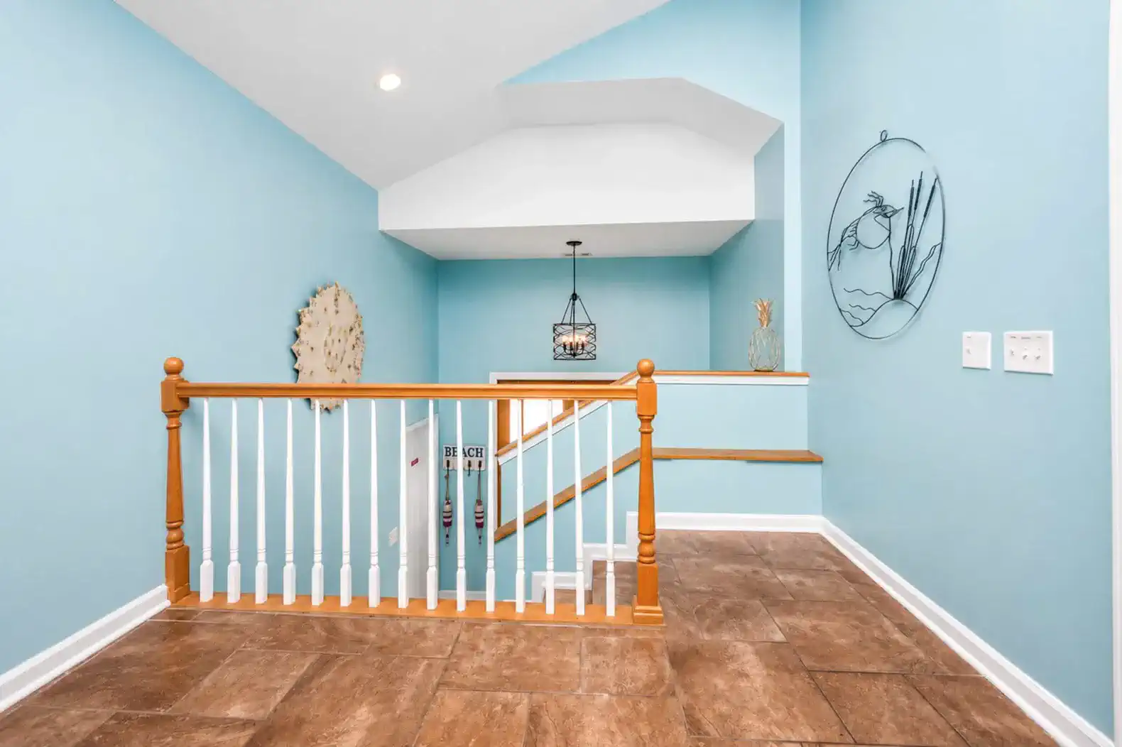 Bright foyer with blue walls and decorative accents leading to upper levels