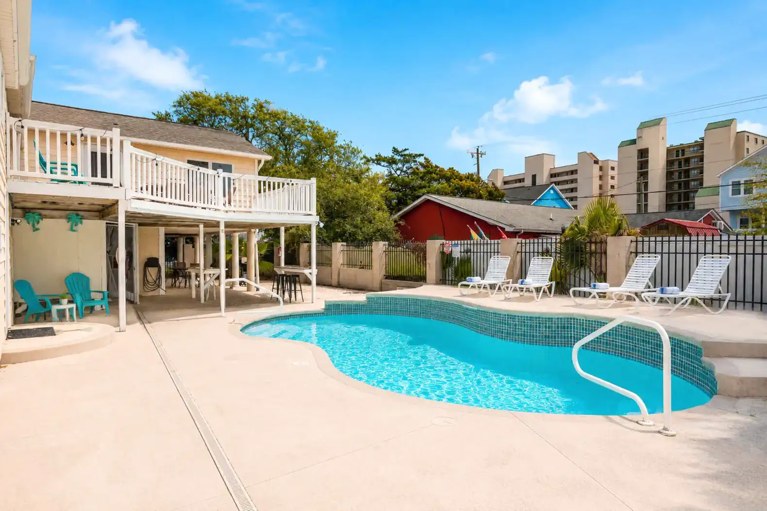 Spacious pool area with lounge chairs and a covered patio