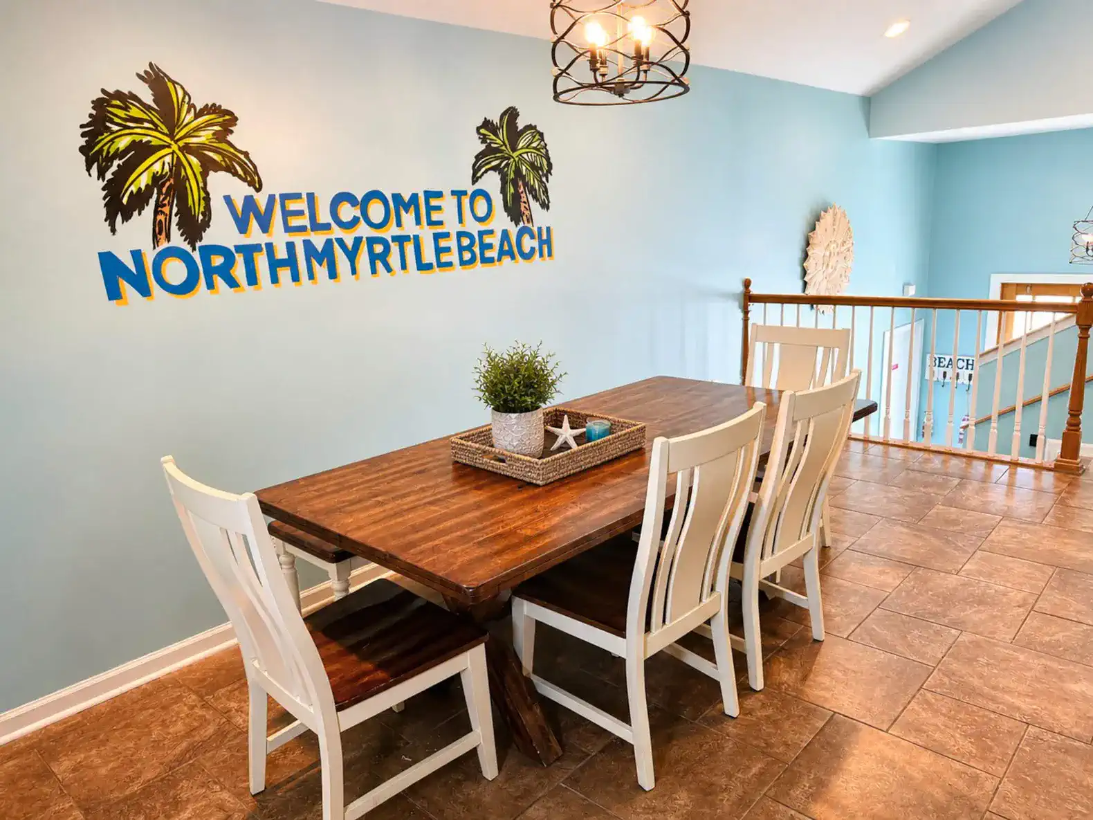 Dining area with a wooden table and chairs, decorated with a welcome sign