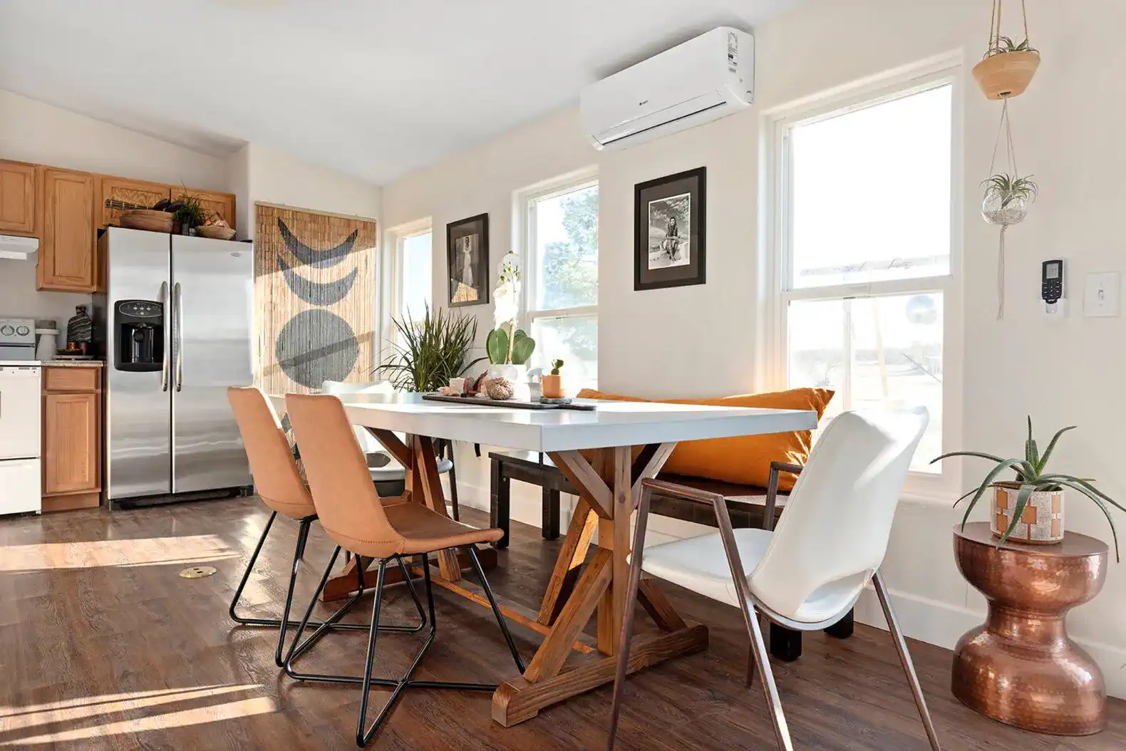 Bright dining area with modern chairs, a wooden table, and large windows letting in natural light