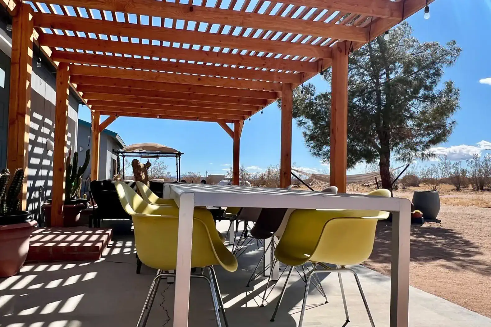Spacious outdoor patio with a pergola and colorful chairs