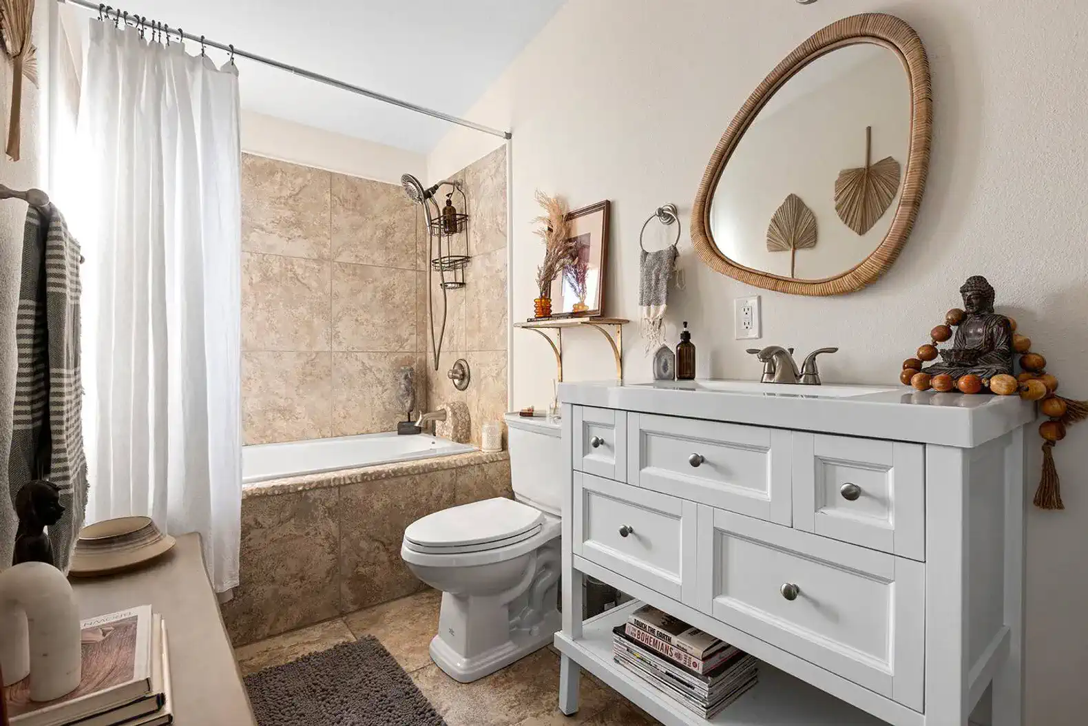 Modern bathroom with a bathtub, white vanity, and decorative elements