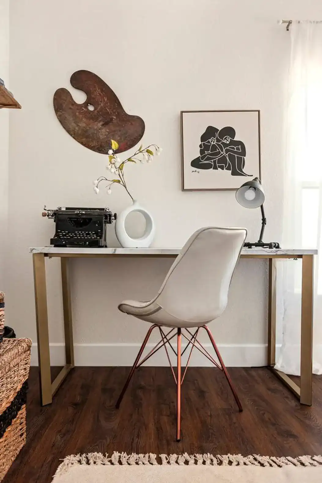 Stylish workspace featuring a modern desk, chair, and decorative art pieces