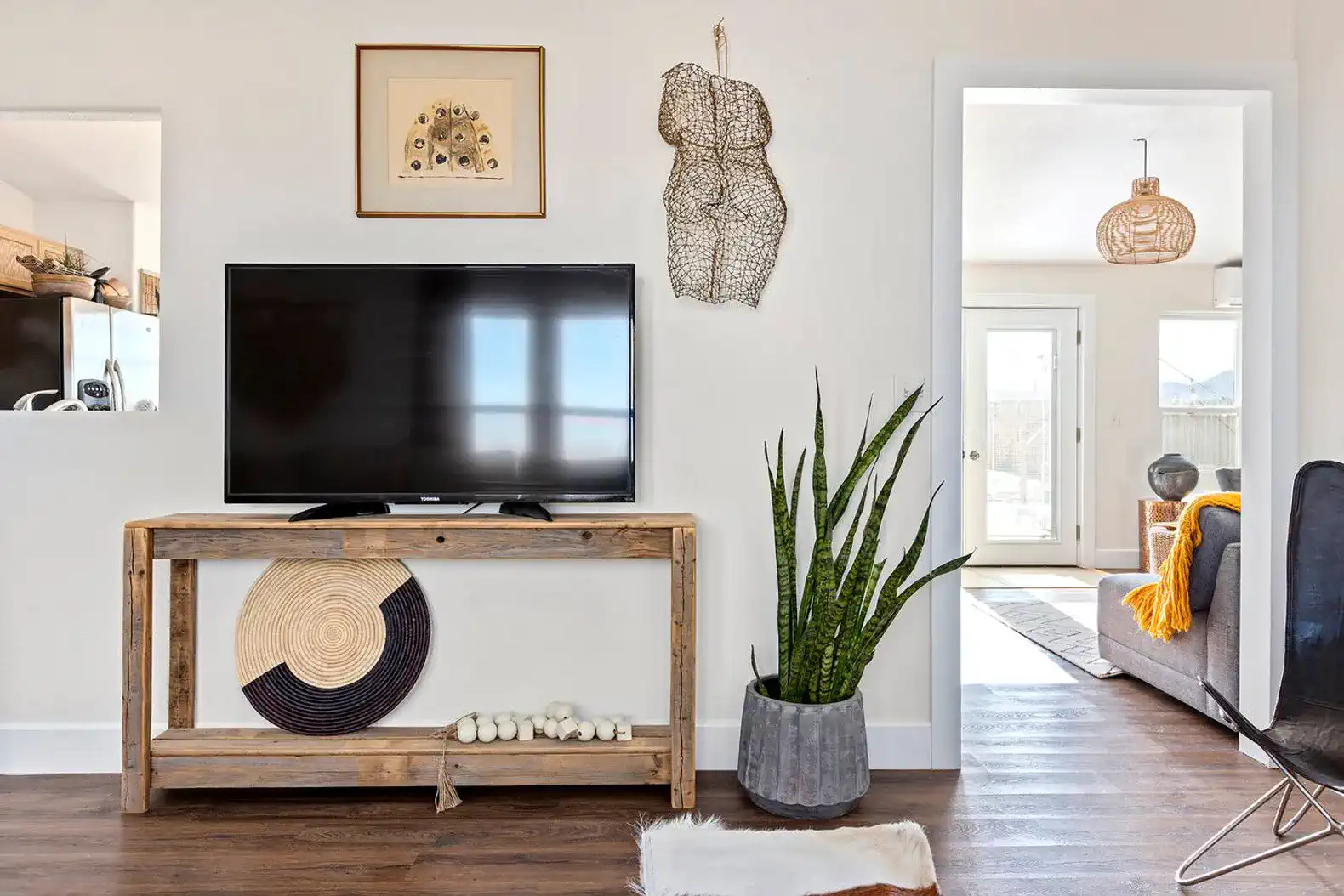Stylish living room with a TV on a wooden console and decorative plants