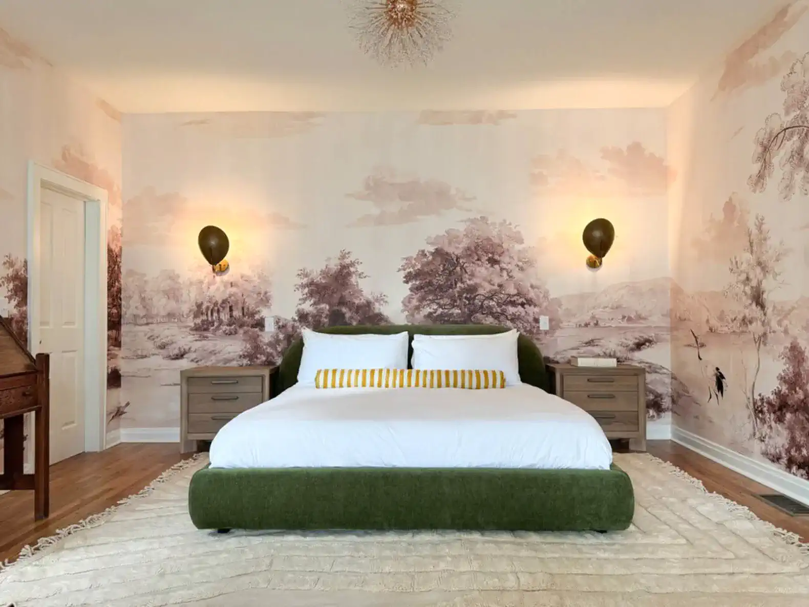 A king size bed, individual lights on each side, and outlets in the sidetables. The door to the left goes into the bathroom.