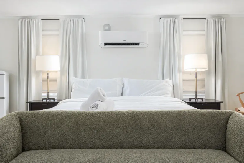 Bright, cozy bedroom with plush king bed, sofa, and AC comfort