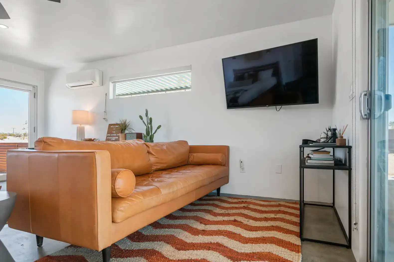 Cozy living room with a leather sofa, TV, and modern decor