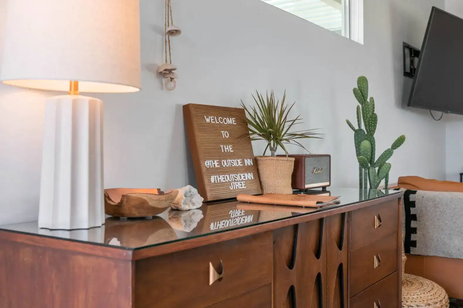 Stylish console table with decorative items and a welcoming sign