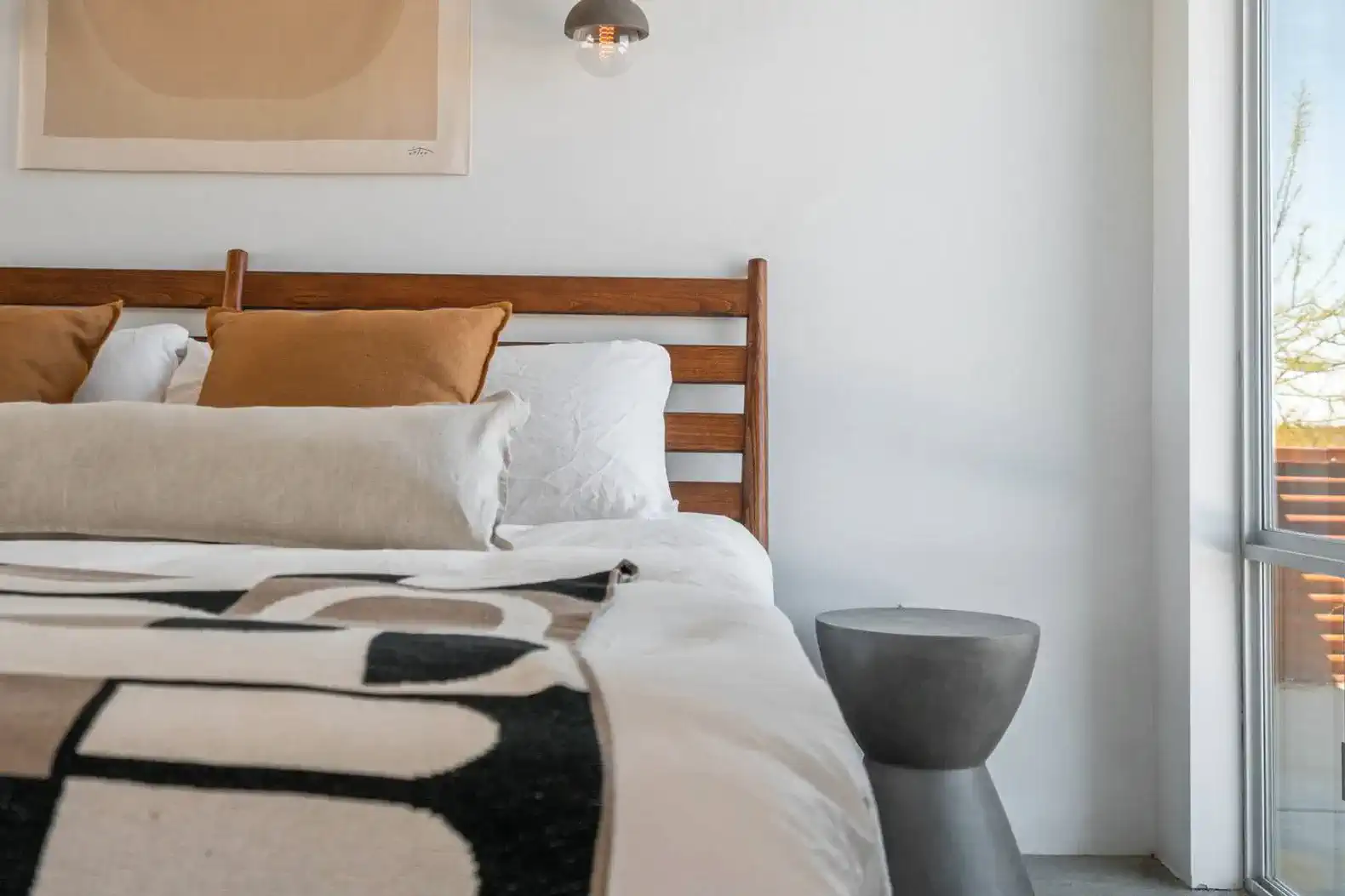 Cozy master bedroom with a wooden bed, decorative pillows, and modern bedside table