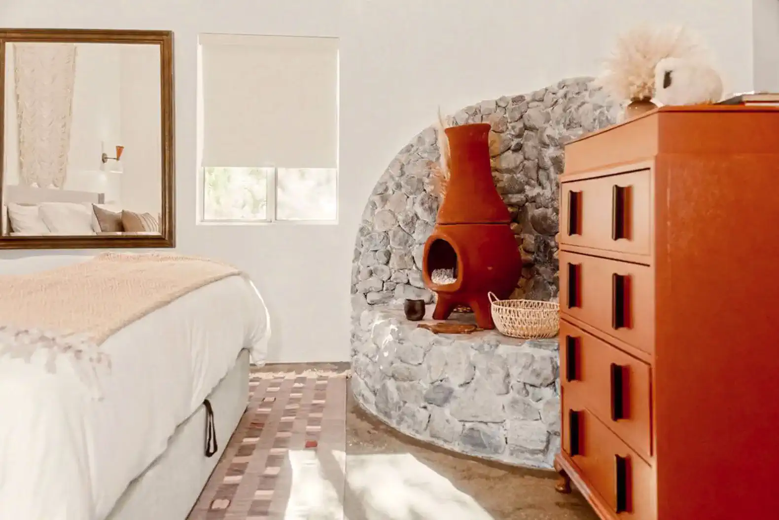 Cozy master bedroom featuring a unique clay fireplace and stylish decor