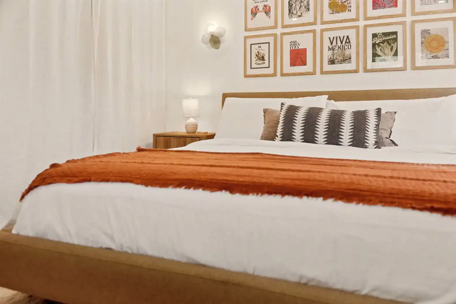 Cozy master bedroom featuring a large bed with decorative pillows and framed art on the wall