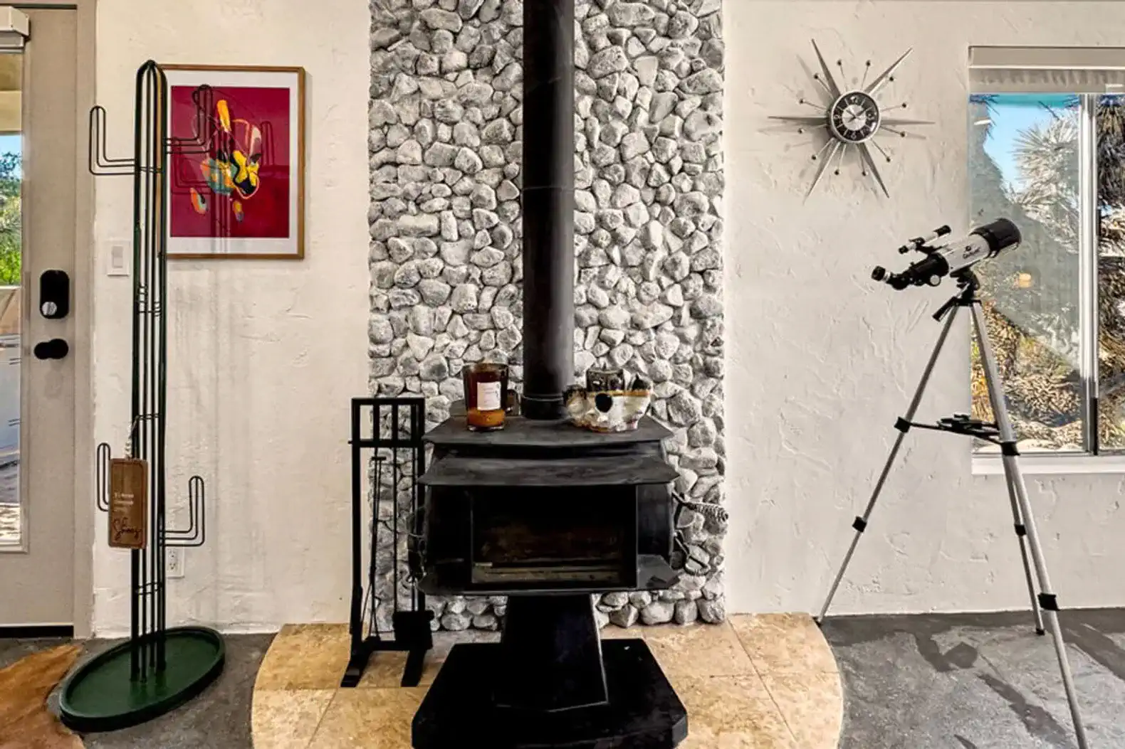 Cozy living area featuring a stone fireplace and telescope with artistic decor