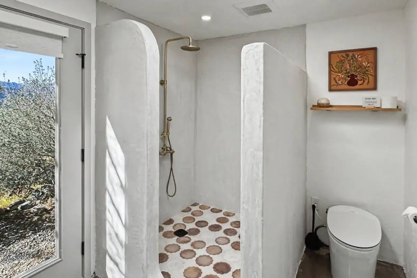 Spacious outdoor shower with natural stone floor and modern fixtures