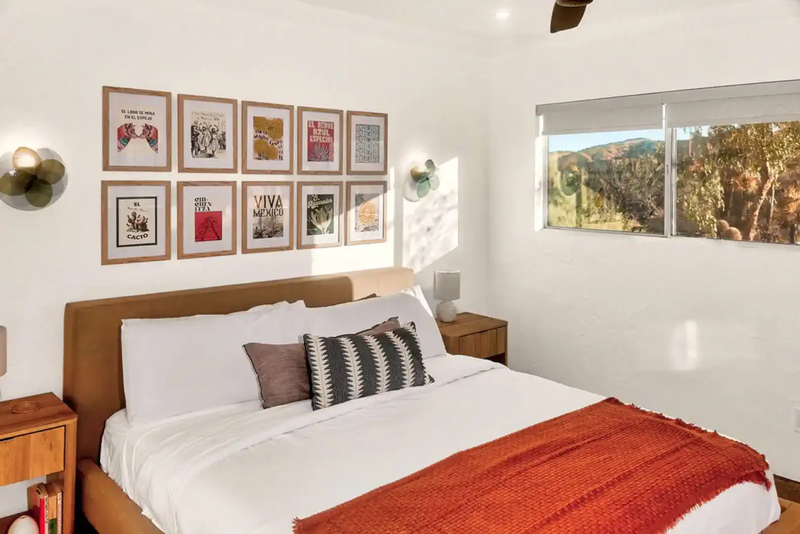 Cozy master bedroom with artwork on the wall and a view of the desert landscape