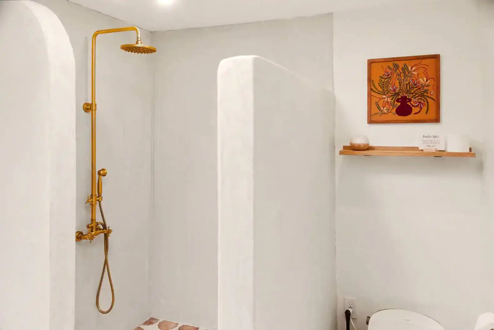 Stylish shower area with gold fixtures and minimalist design