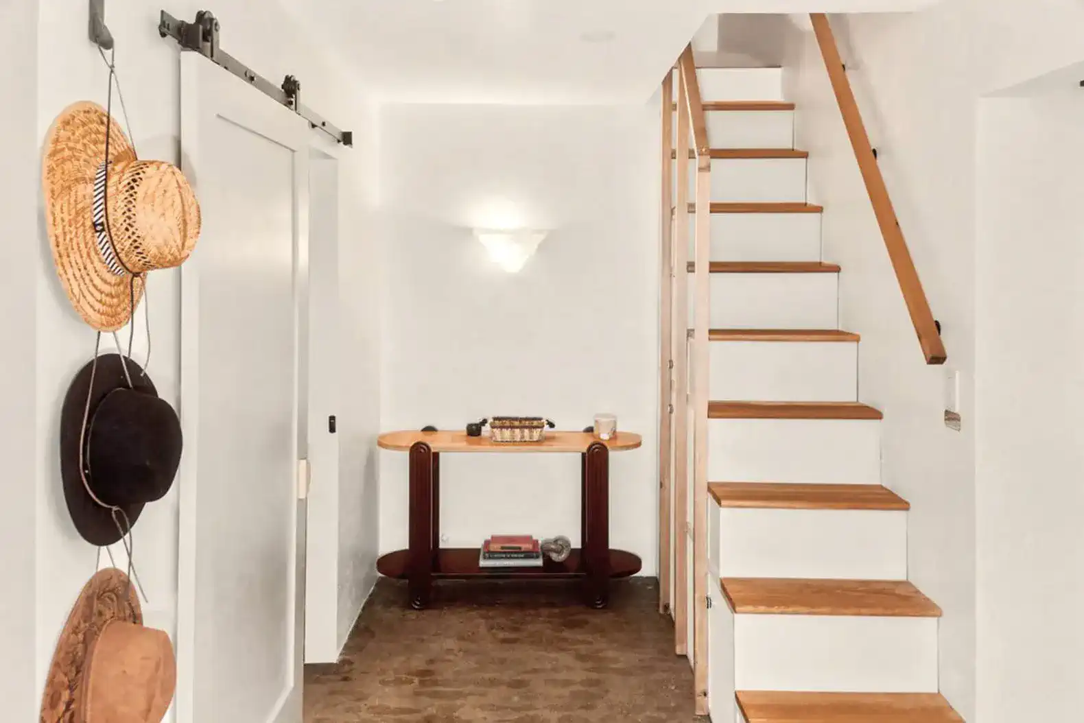 Stylish entrance with a console table and decorative hats on the wall
