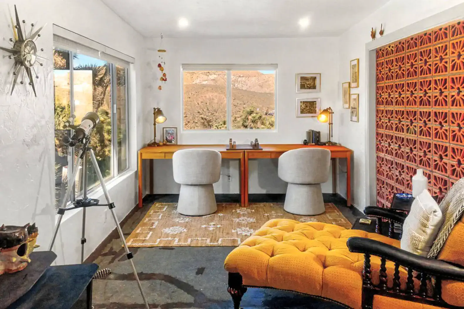 Cozy workspace with two chairs, a telescope, and a view of the desert landscape