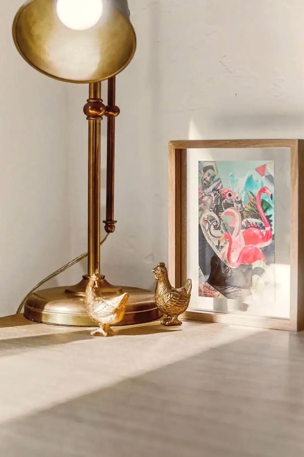 Decorative lamp with golden chicken figurines and a colorful framed artwork