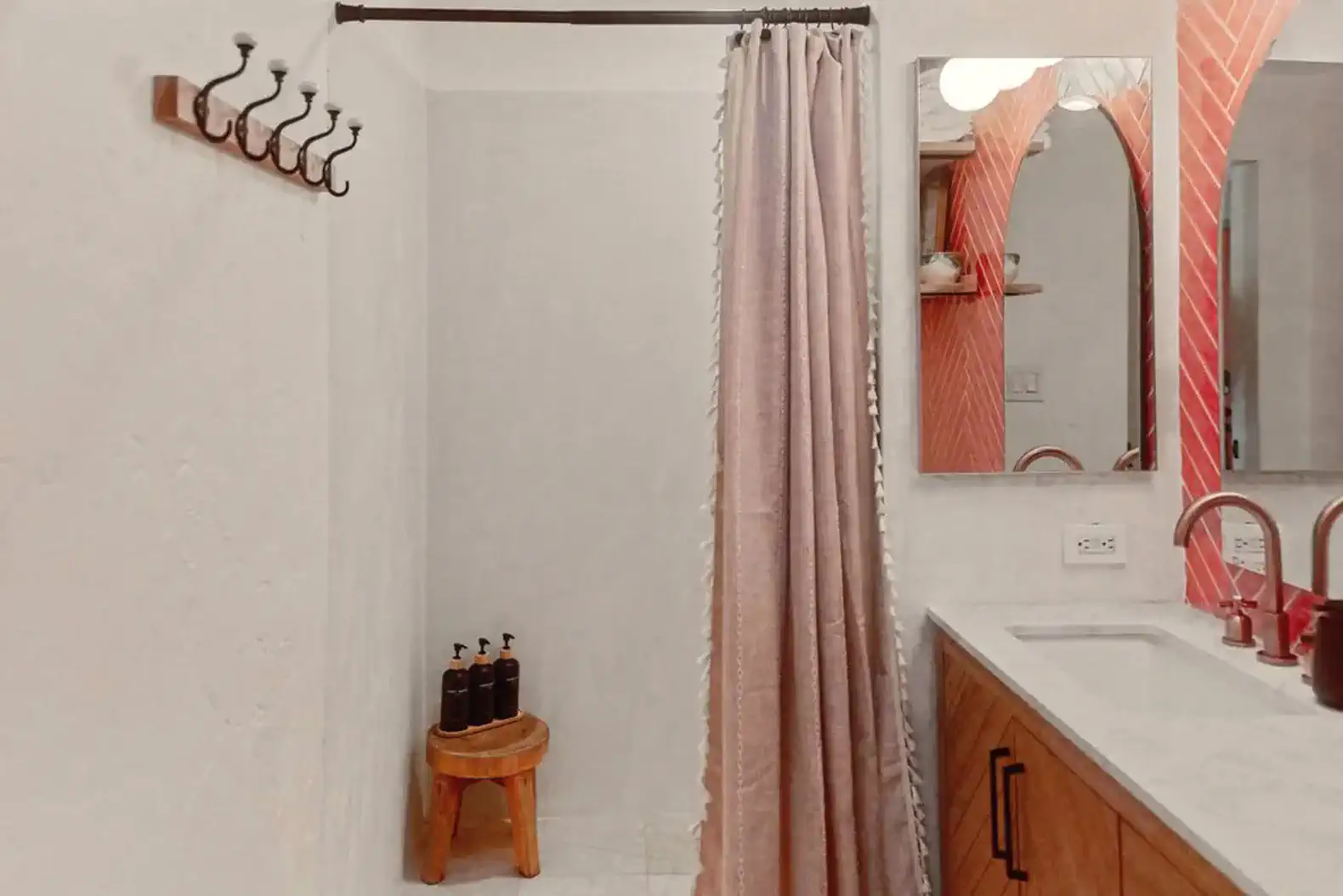Stylish bathroom featuring a shower curtain, wooden stool, and modern sink with mirror