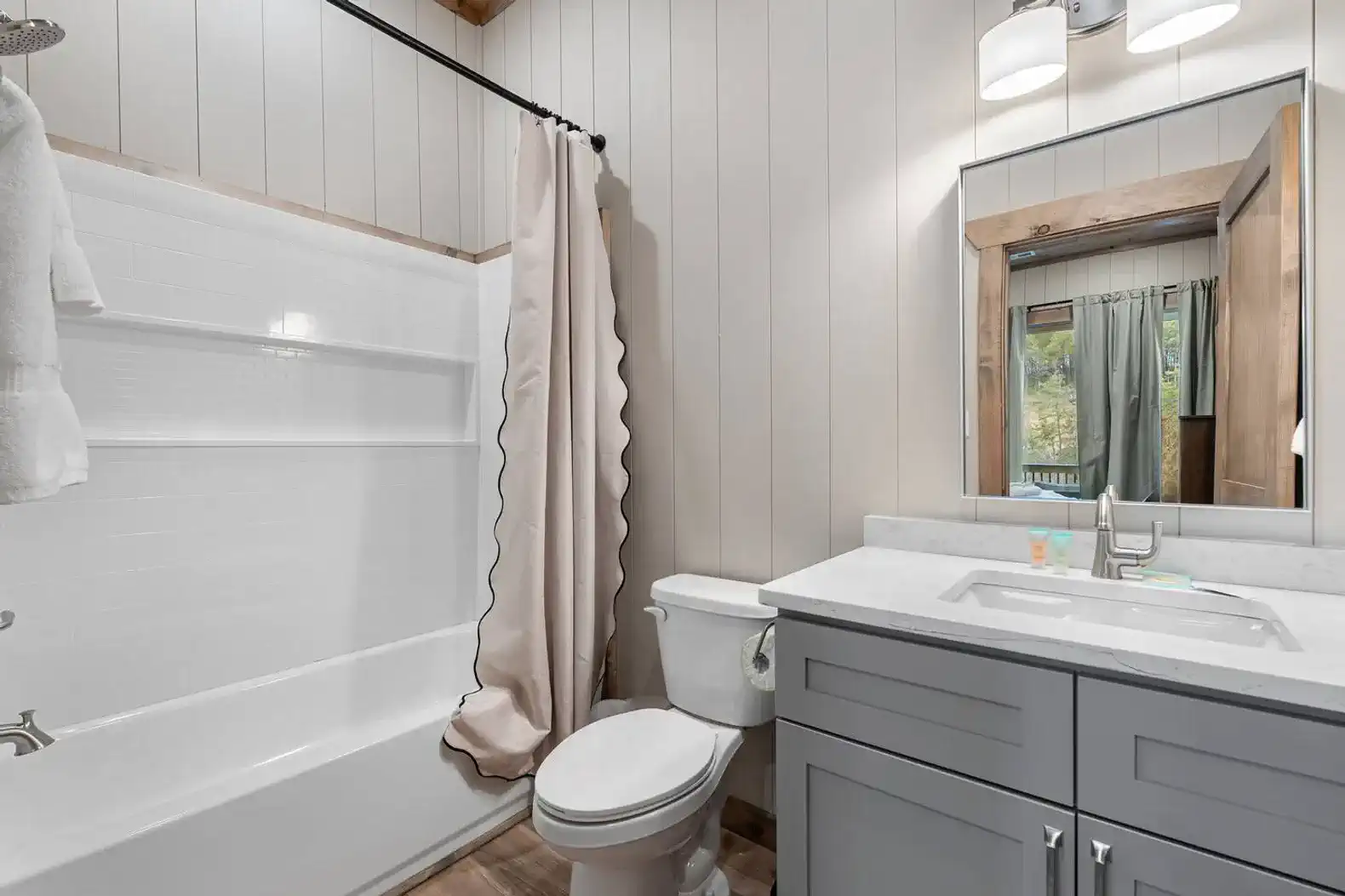 Modern bathroom with a tub, shower curtain, and stylish vanity