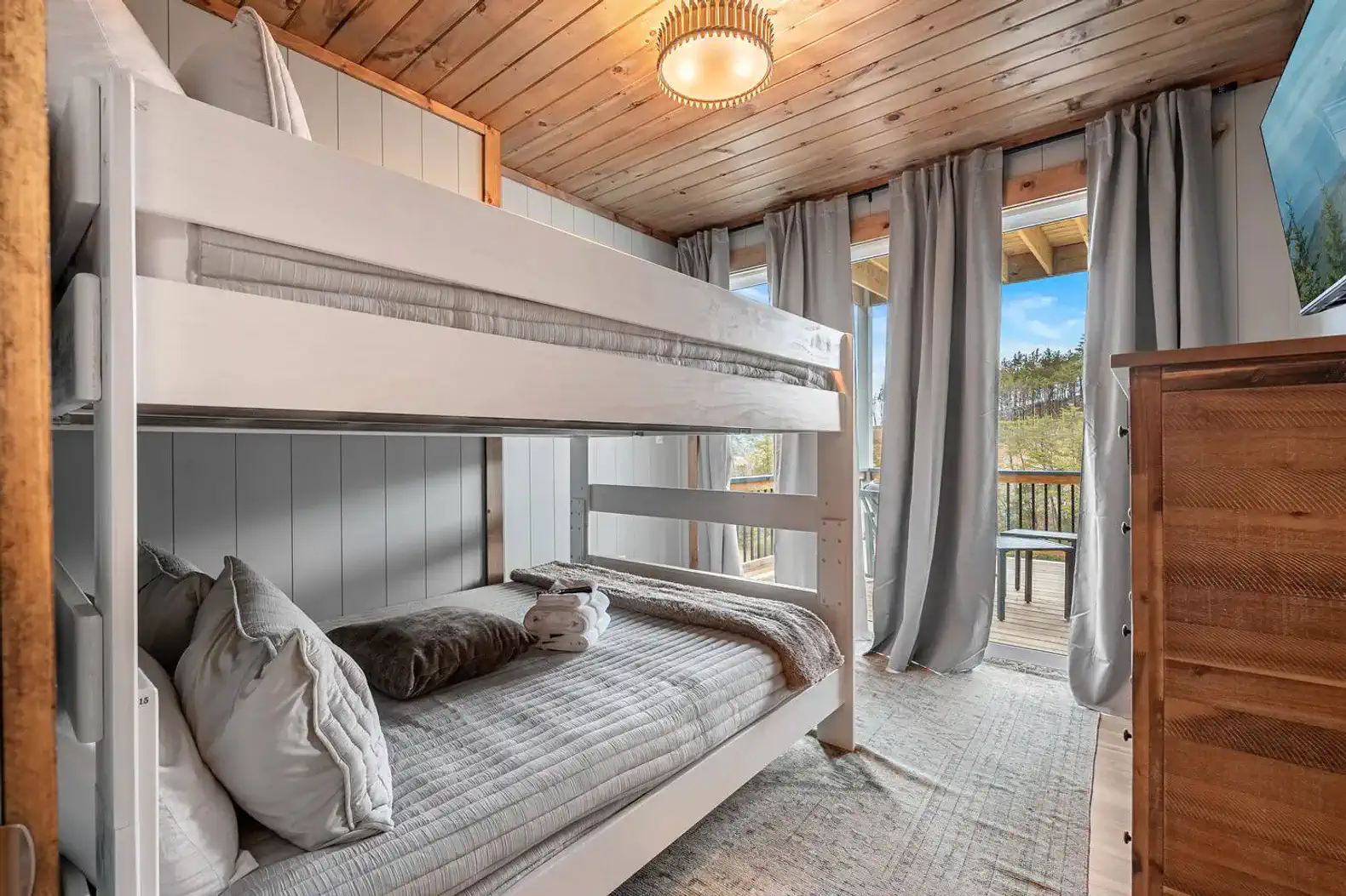 Cozy bunk room with natural light and access to a balcony