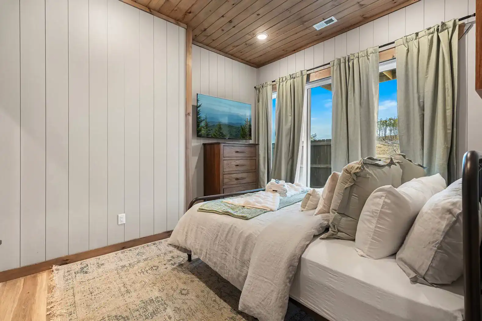 Cozy guest bedroom with natural light and wooden accents