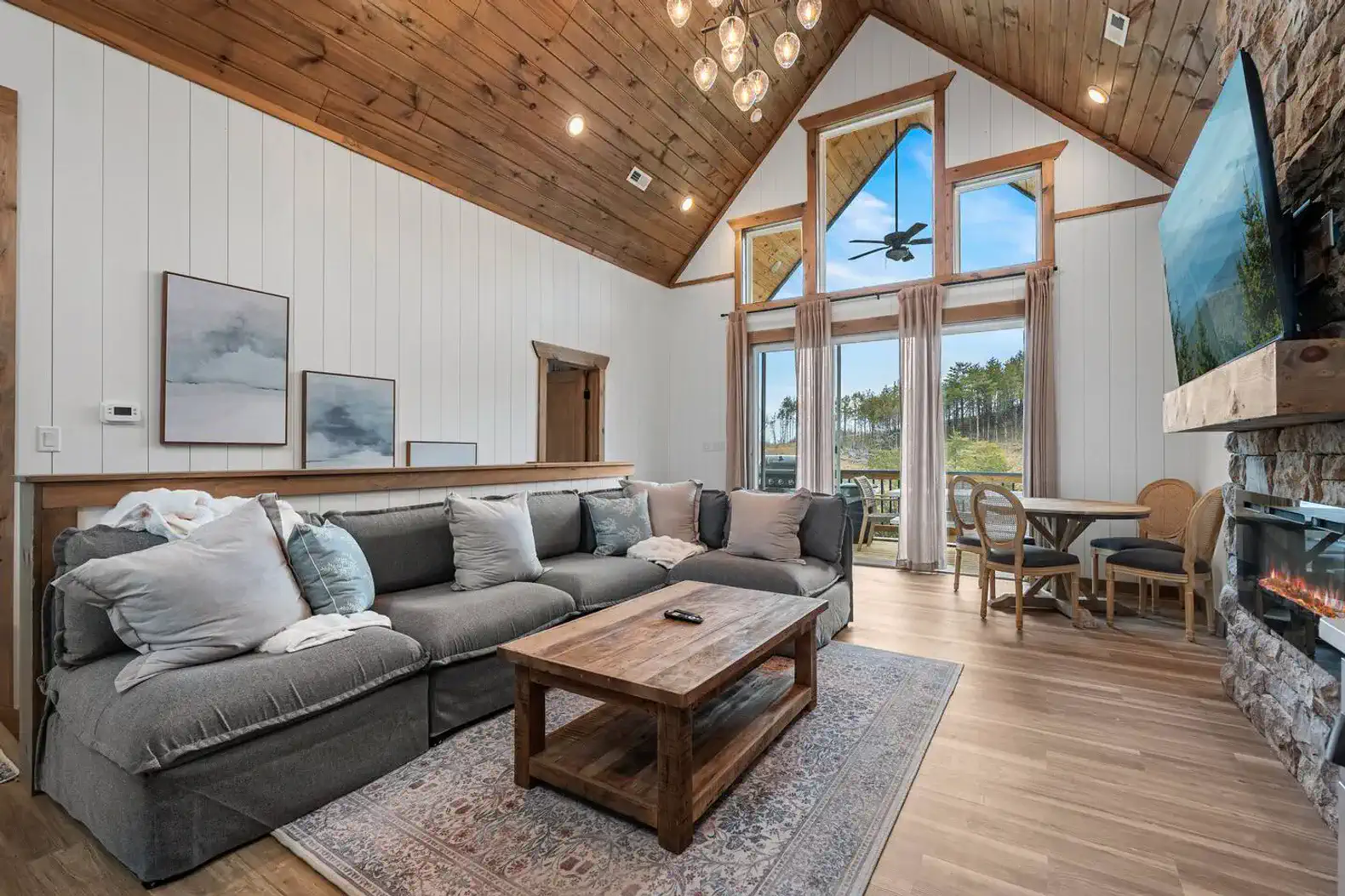 Spacious living room with large sectional sofa and stone fireplace overlooking scenic views