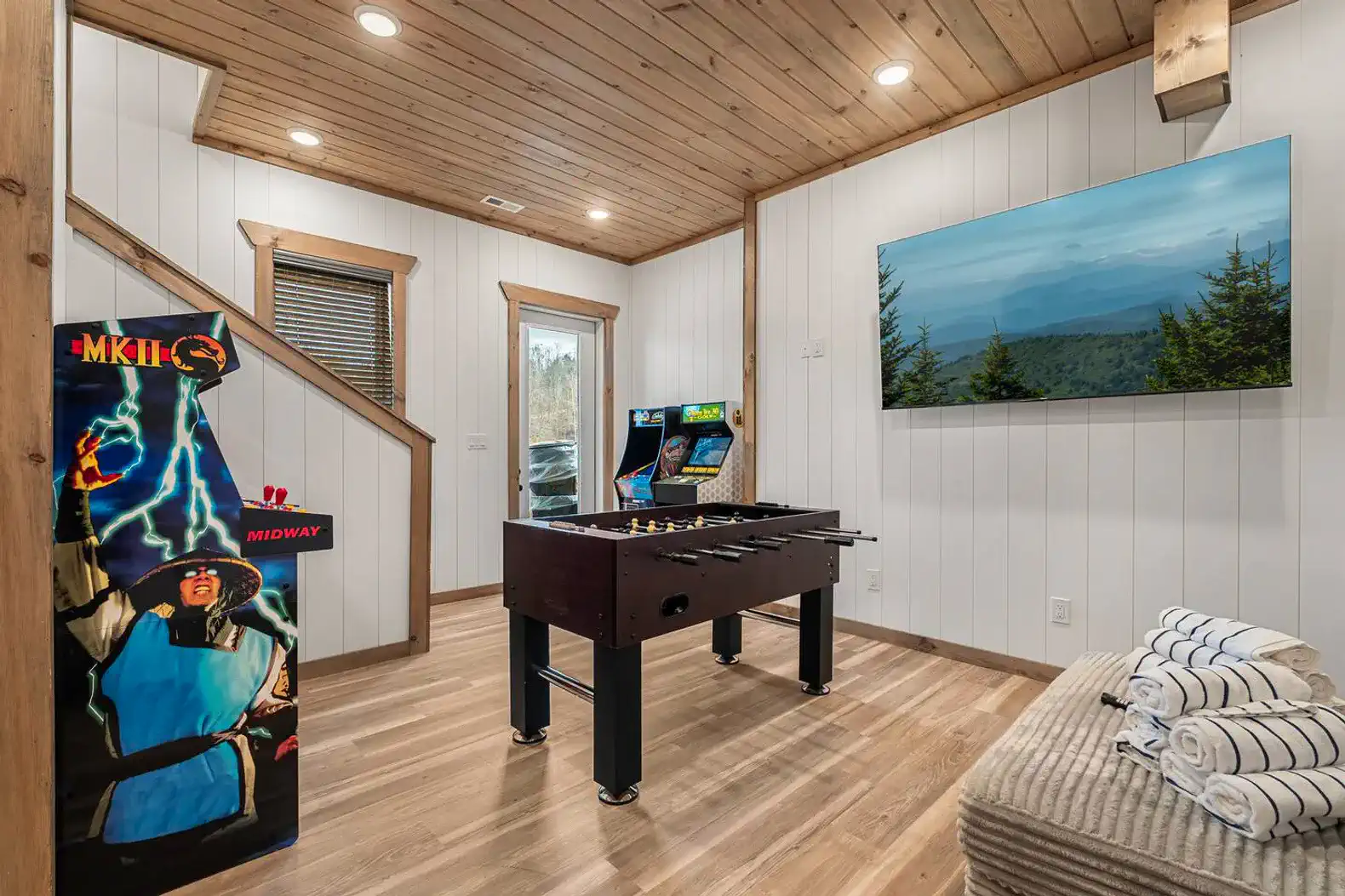Game room featuring foosball table and arcade machine with mountain view