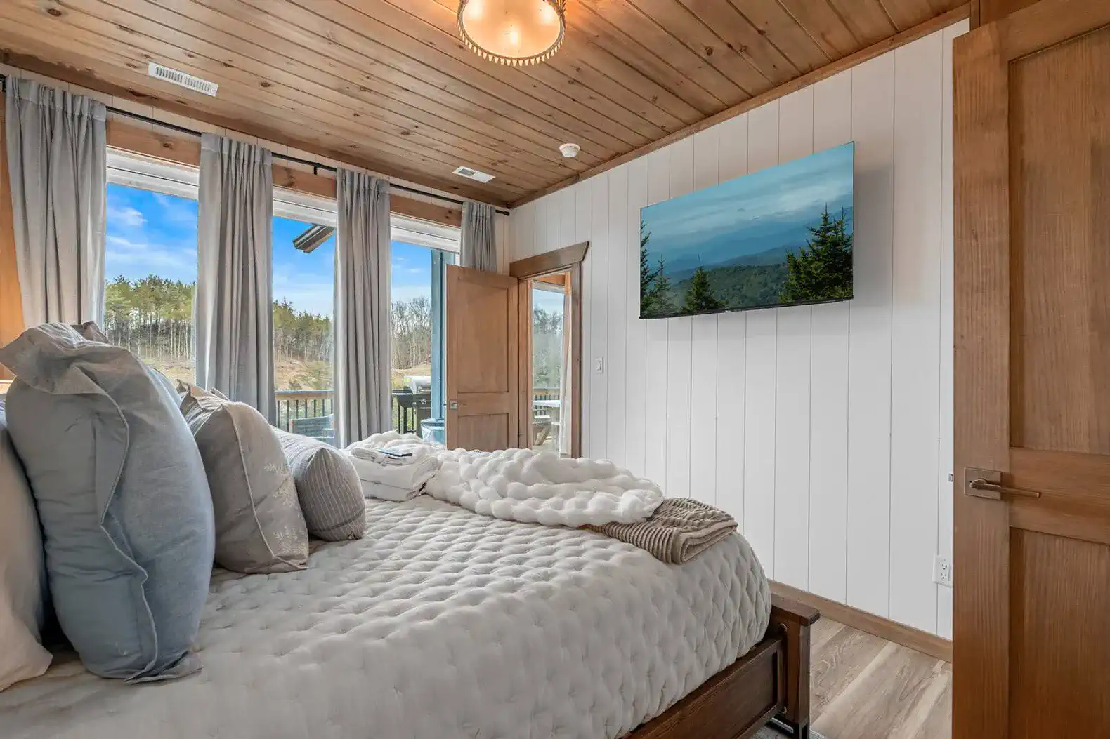 Cozy master bedroom with large windows and mountain views