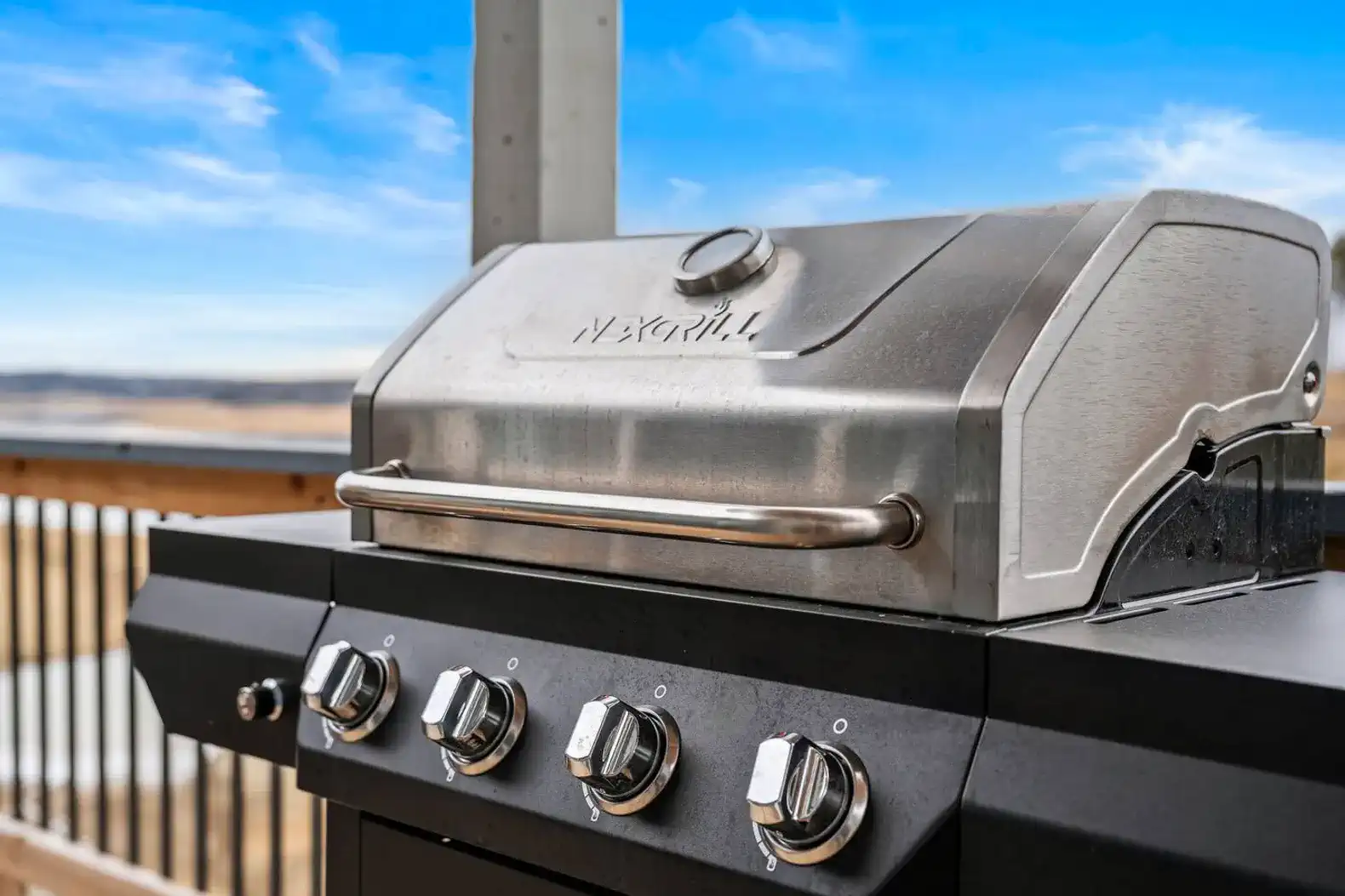 Stainless steel BBQ grill on a deck with scenic views