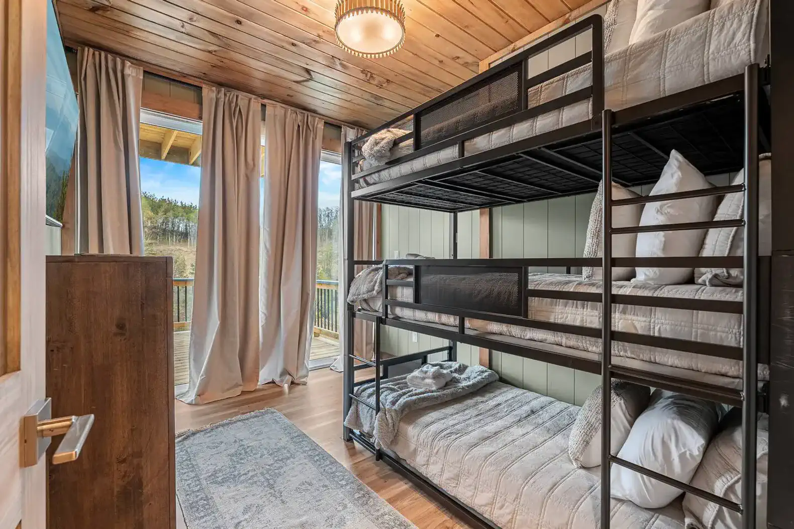 Cozy bunk room with large windows and natural light