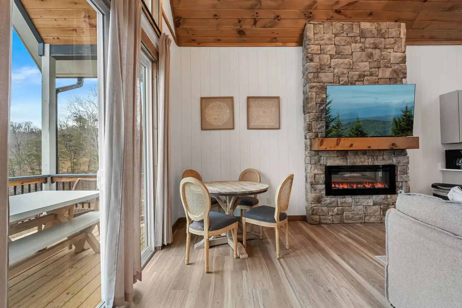 Cozy dining area with a stone fireplace and large windows offering scenic views