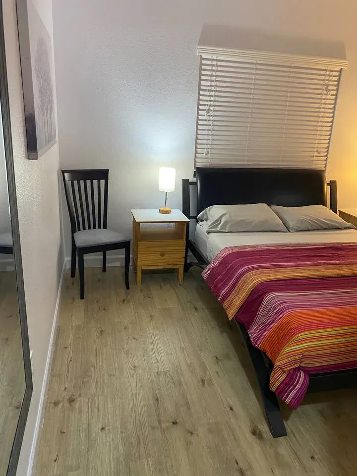 Kleines Schlafzimmer mit Queensize-Bett und Holzböden.