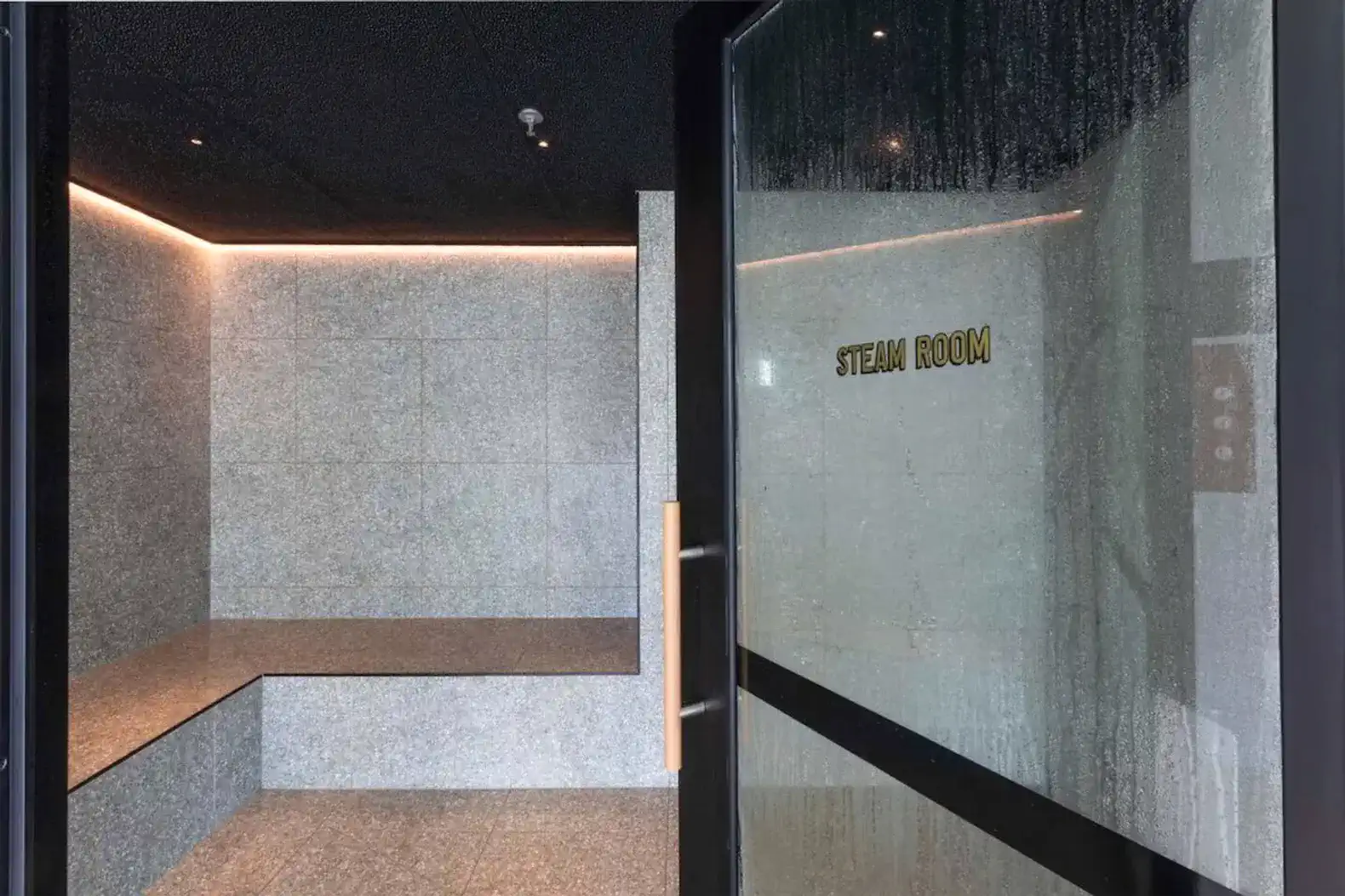 Modern steam room with sleek stone benches and ambient lighting