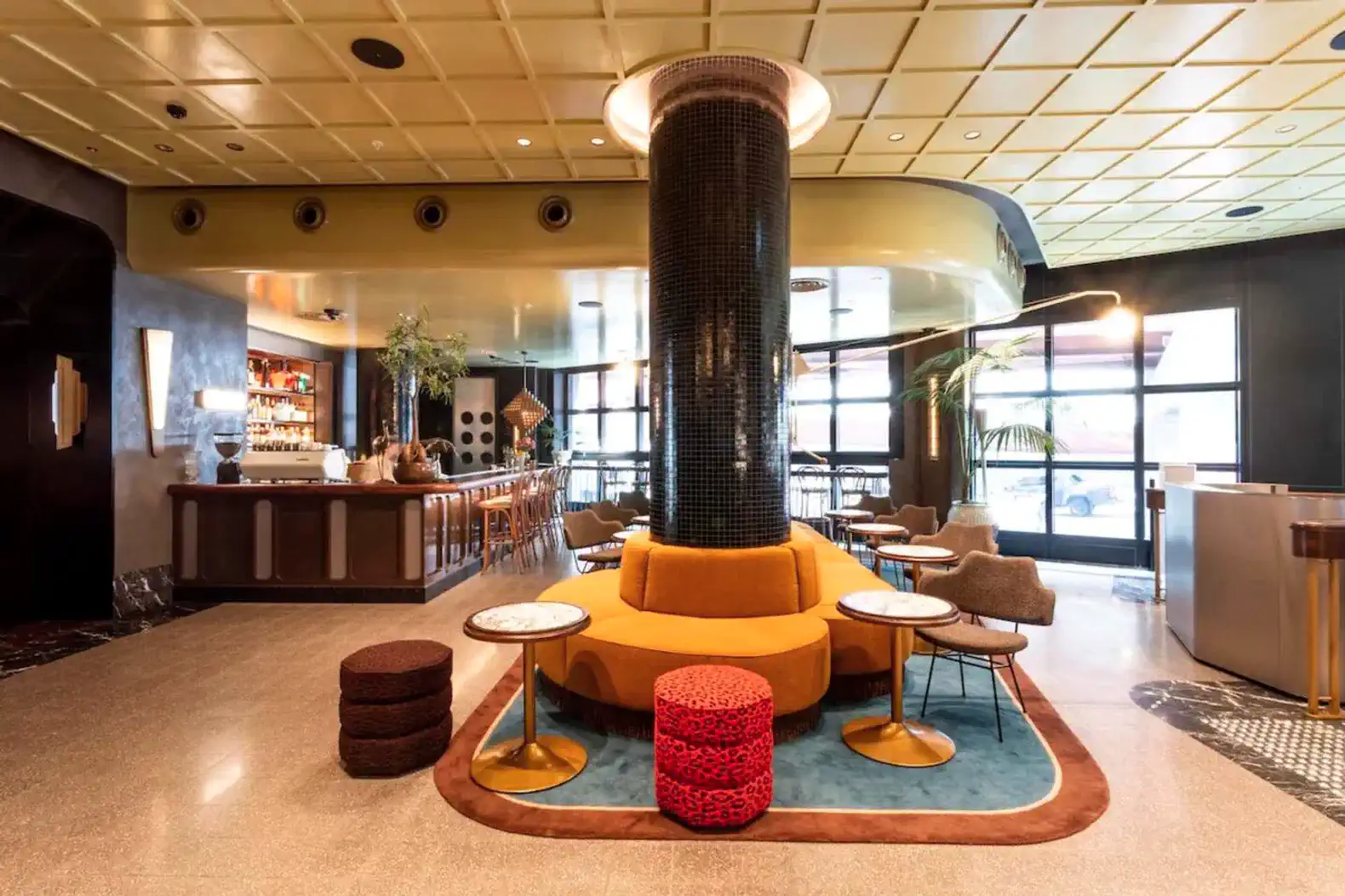 Stylish lounge area with colorful seating and a bar in the background