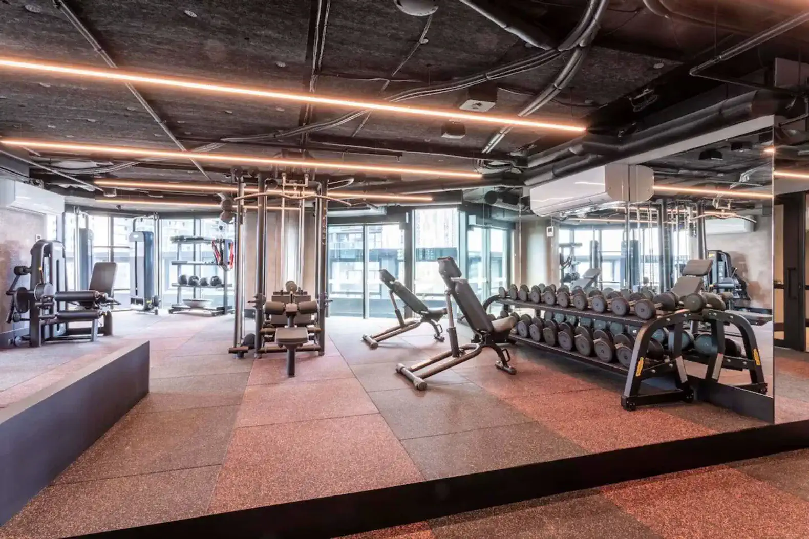 modern gym with various weightlifting equipment and large windows