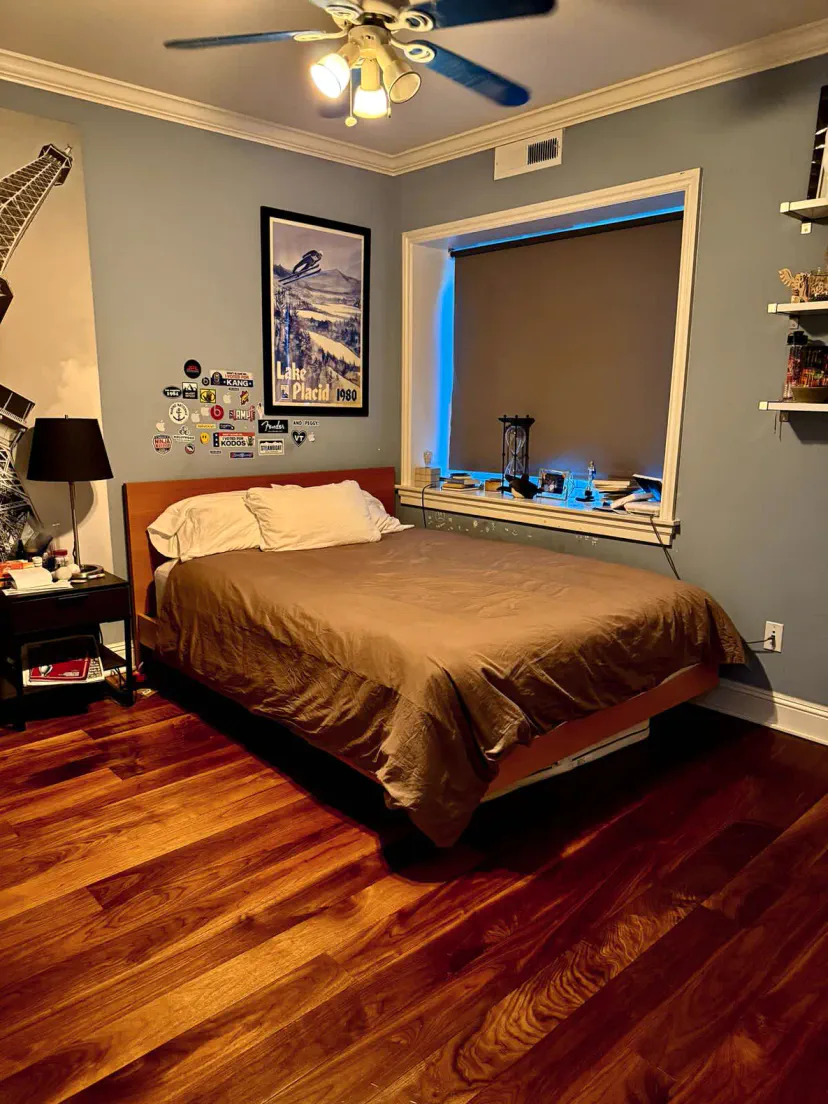 Cozy bedroom with a wooden bed, hardwood floors, and wall art
