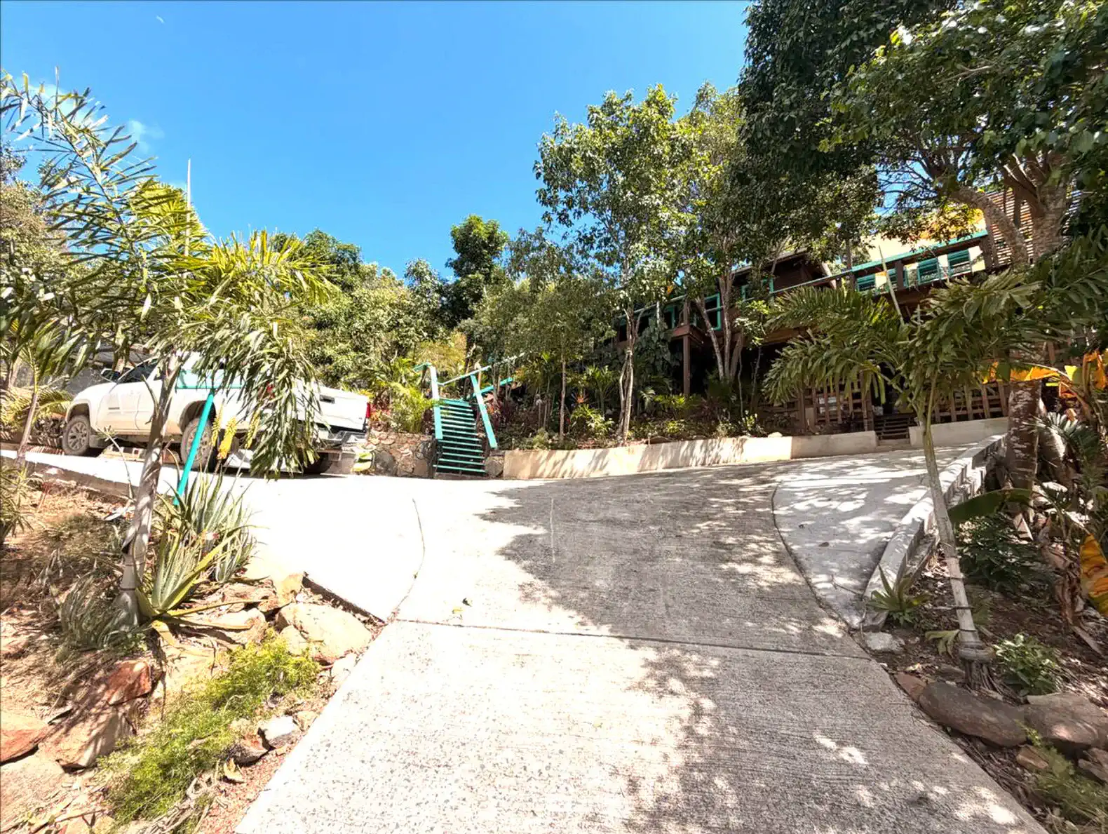 Driveway leading to Cocoa Tea Villa surrounded by lush greenery and tropical plants