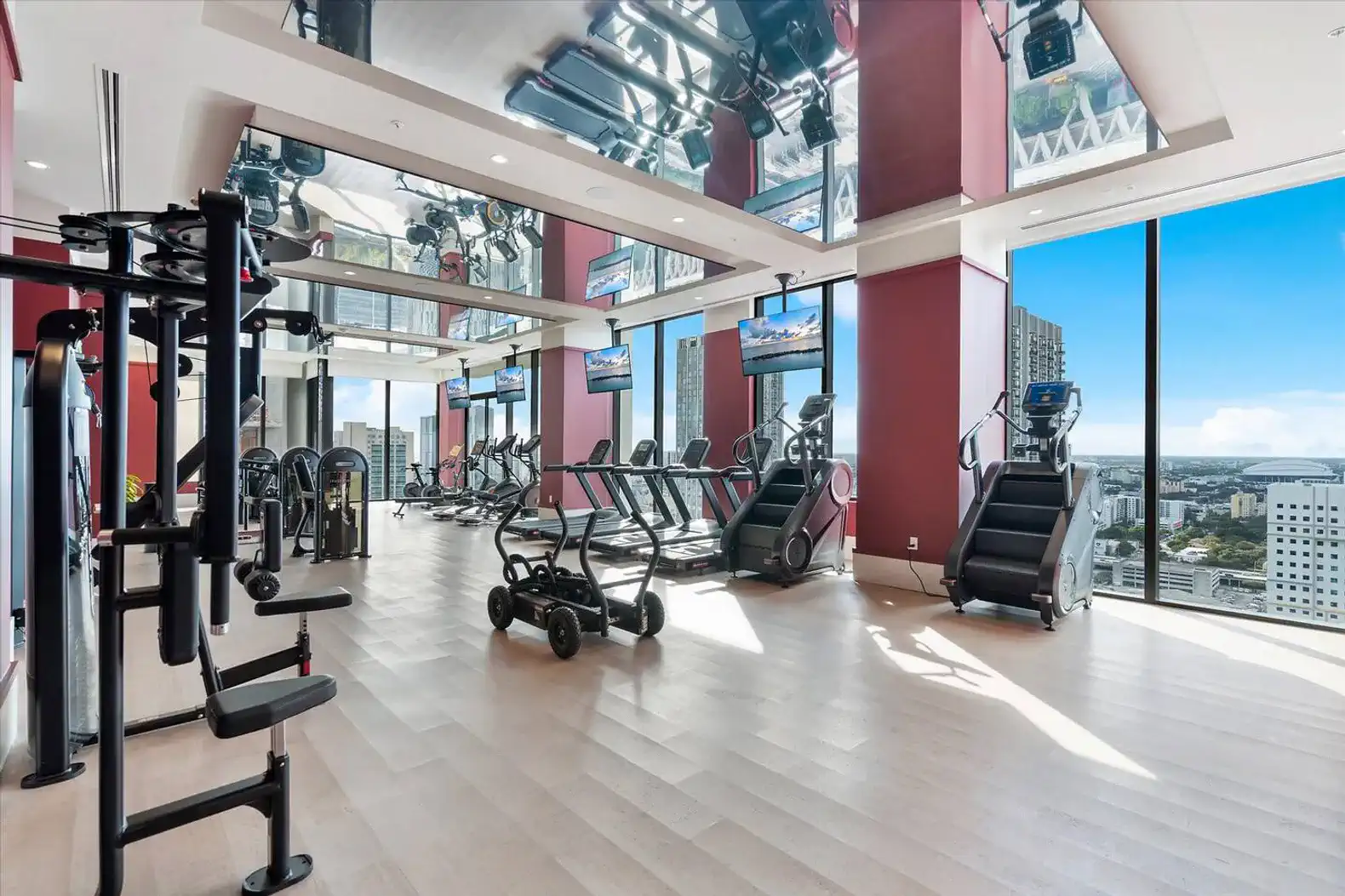 modern fitness center with city views and various exercise equipment