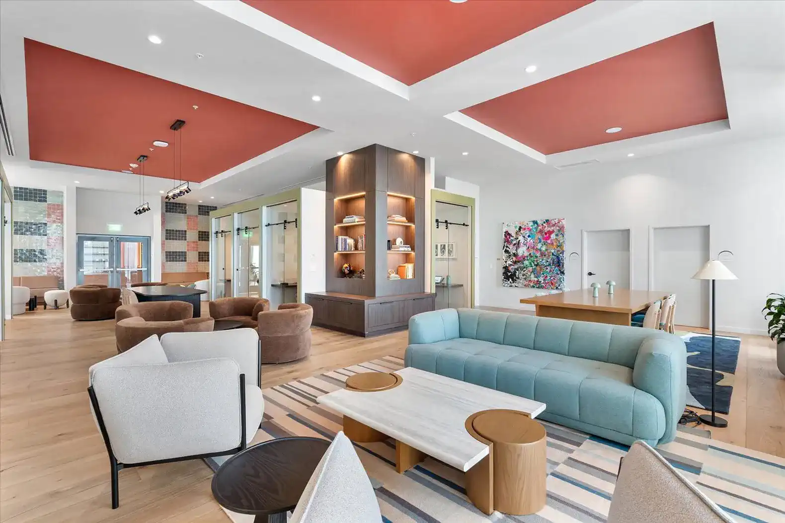 Spacious living area with modern furniture, colorful ceiling, and art pieces
