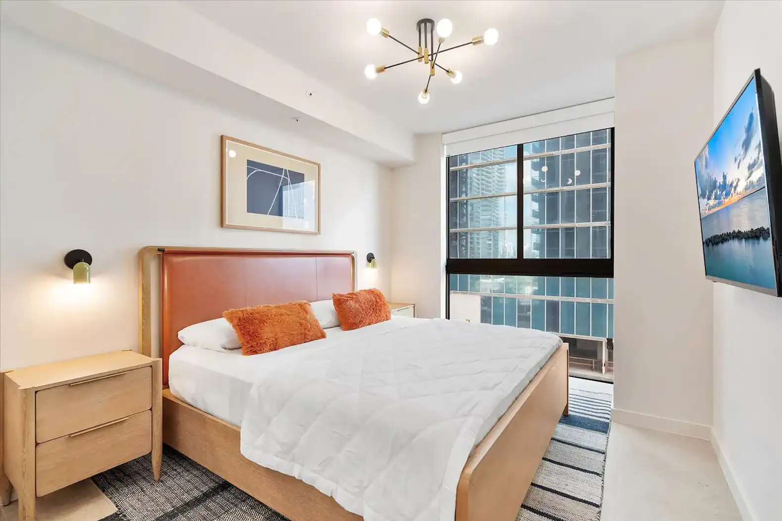 Bright master bedroom with large window and city views