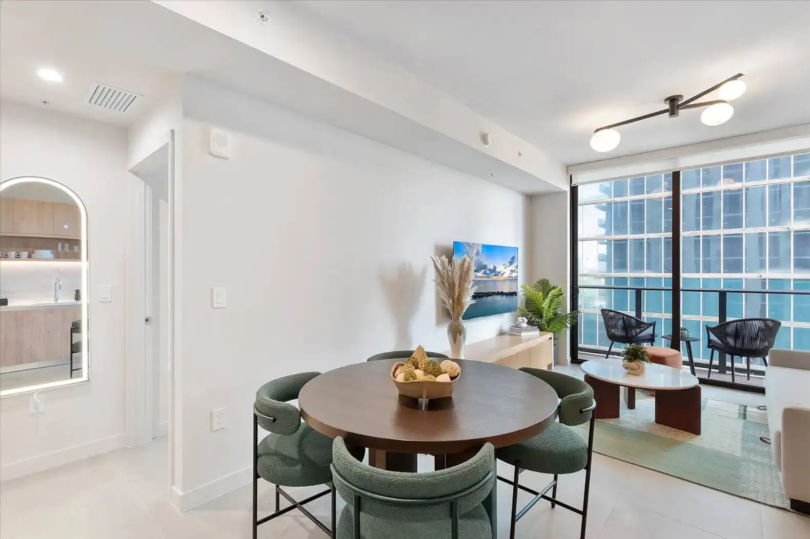 Modern dining area with round table and stylish chairs, featuring a view of the city through large windows
