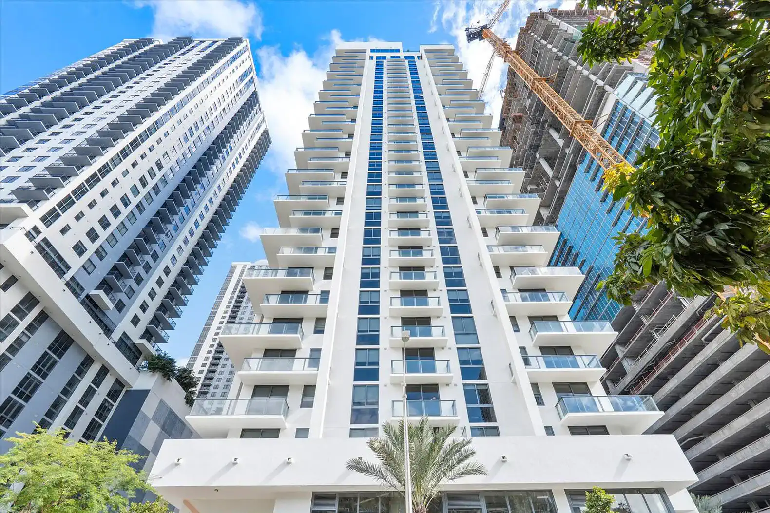 Modern high-rise building with balconies and city skyline