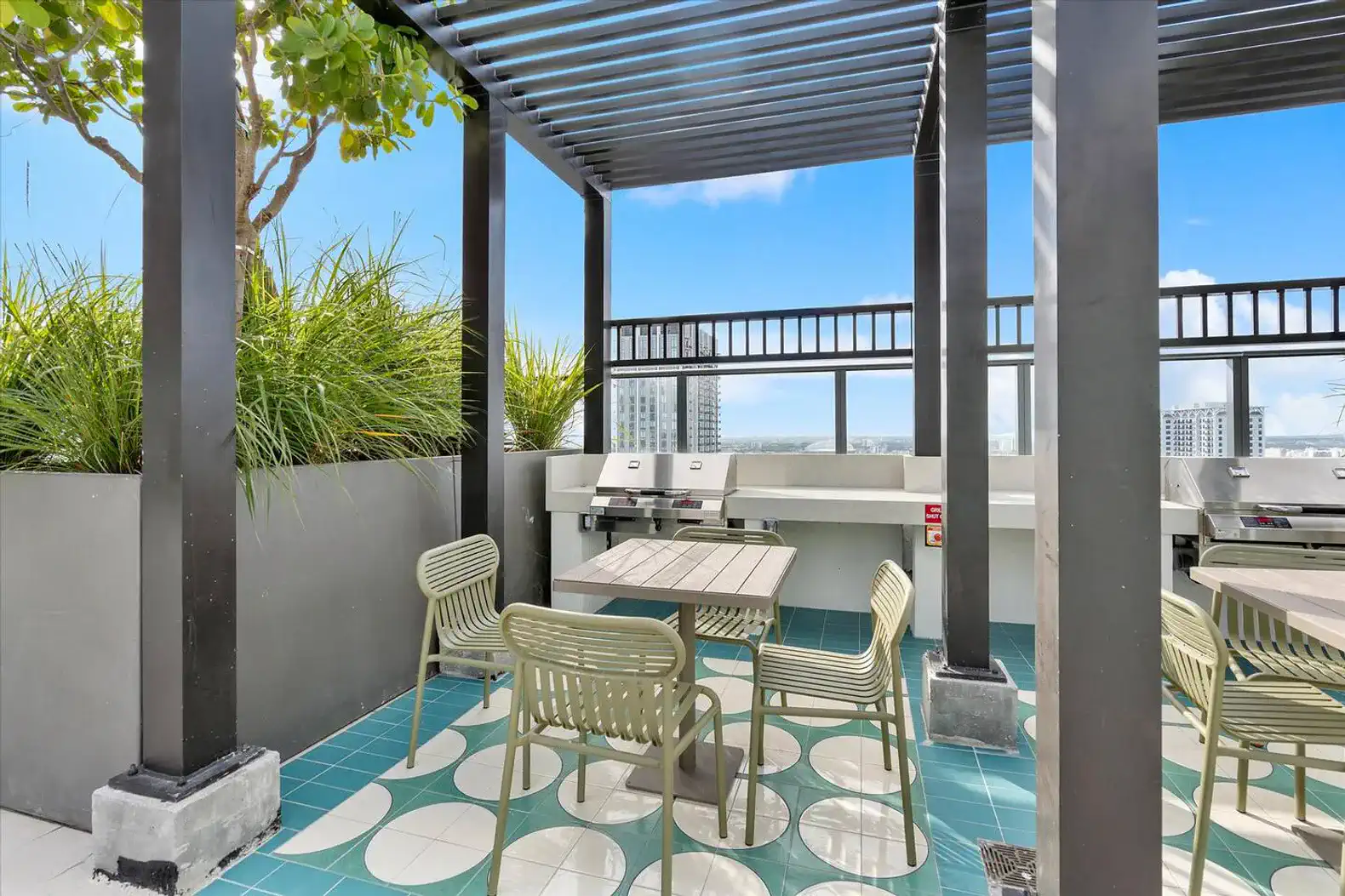 Rooftop grilling area with seating and city views