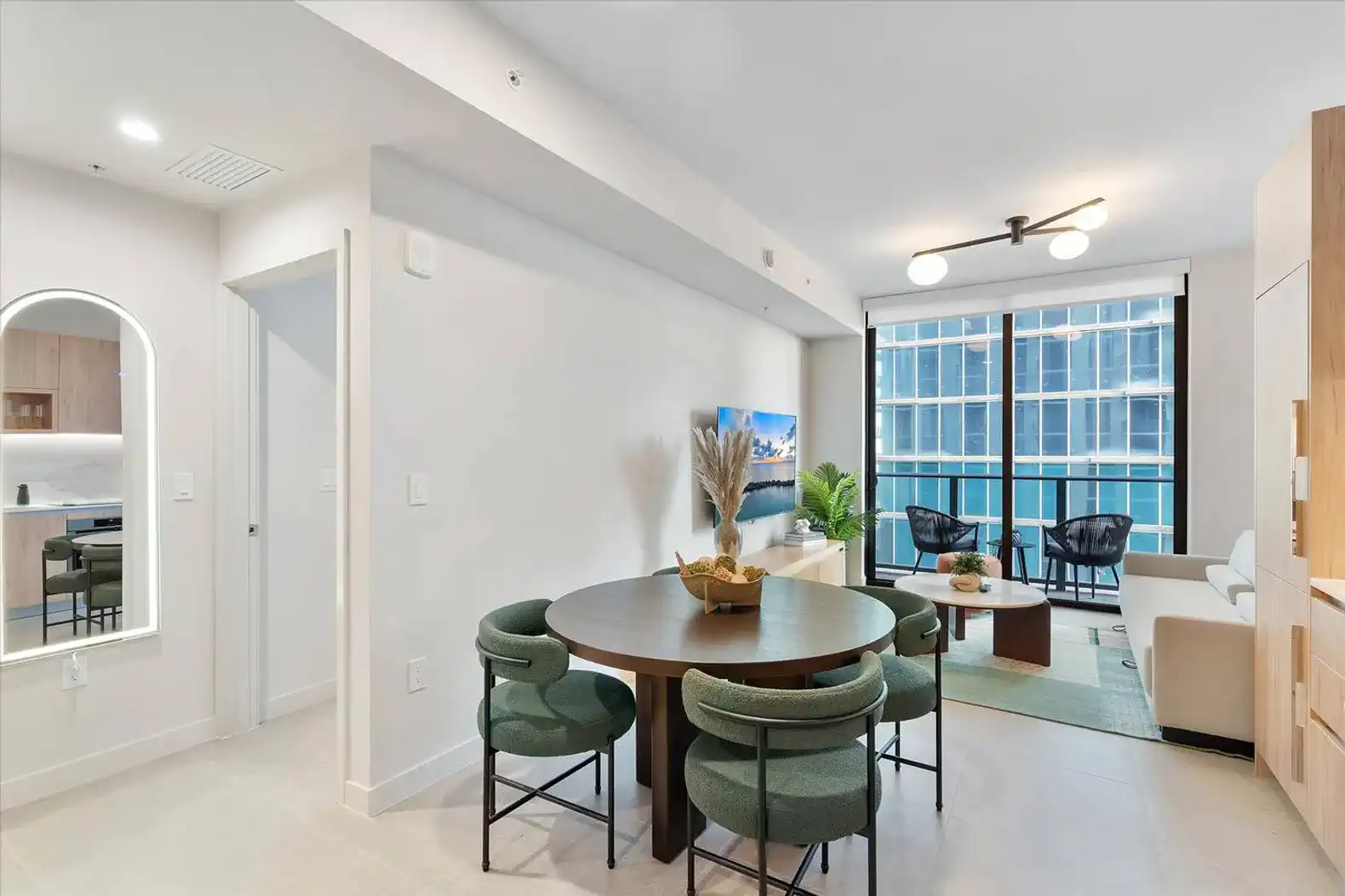 Modern dining area with round table and stylish chairs next to a cozy living space