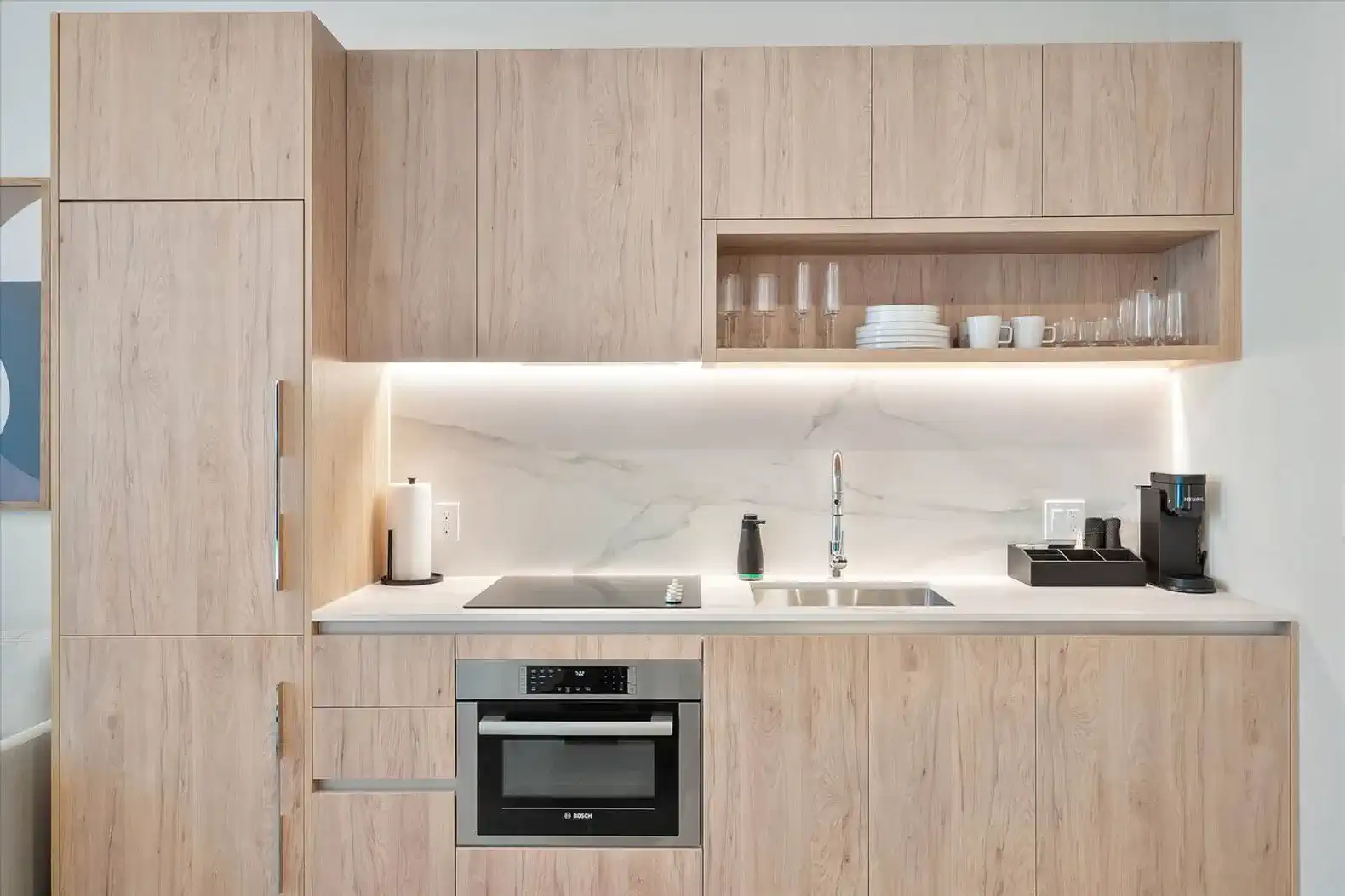 Modern kitchen with wooden cabinetry, marble countertop, and built-in appliances