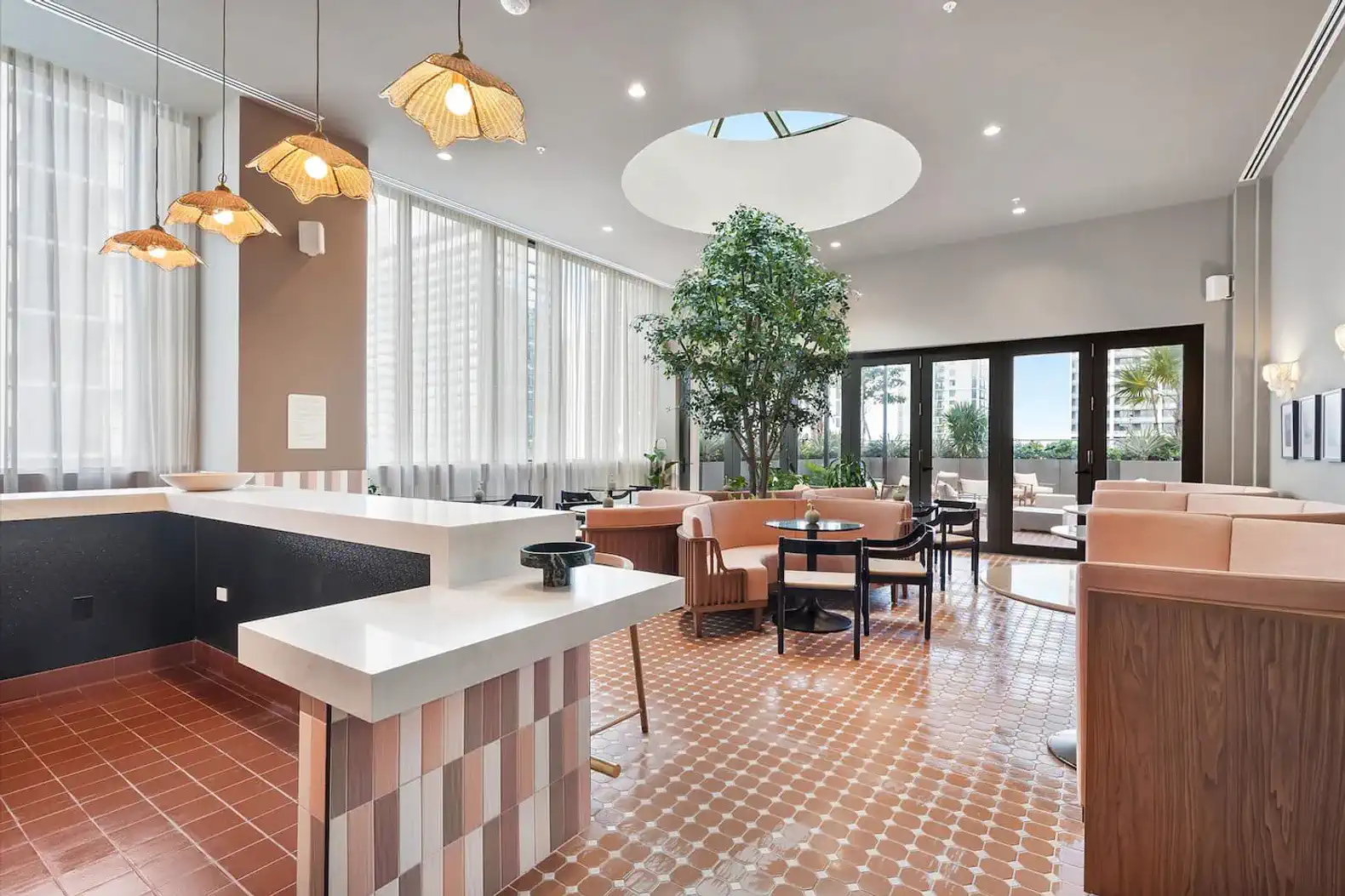 Stylish open space with modern decor, large windows, and a central tree feature