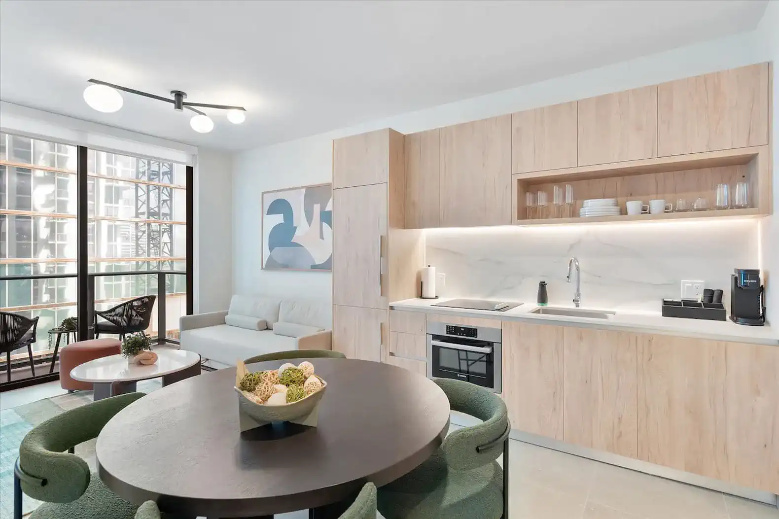 Modern kitchen with wooden cabinetry and dining area featuring a round table