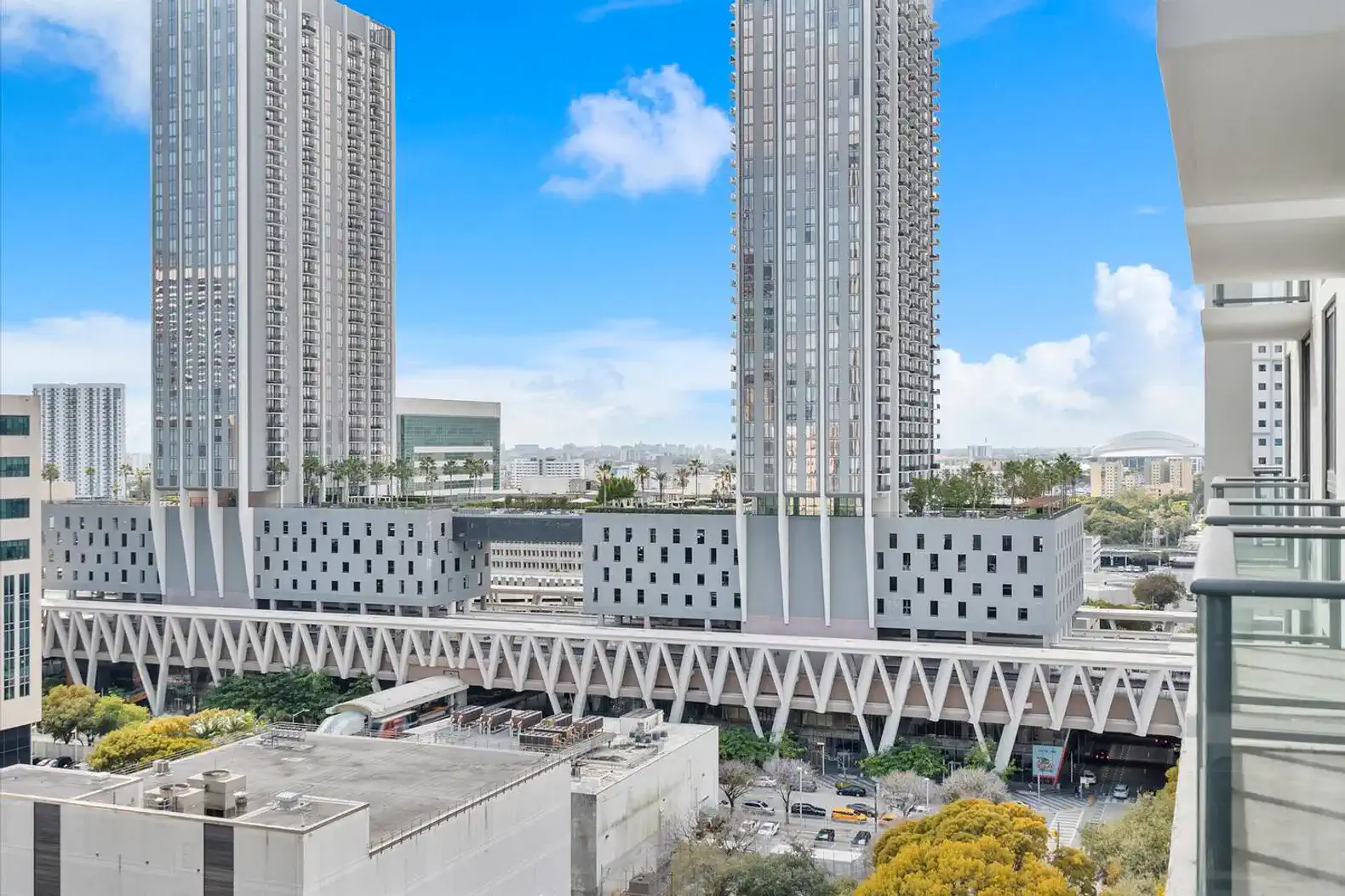 Stunning city views from the balcony overlooking modern buildings and greenery
